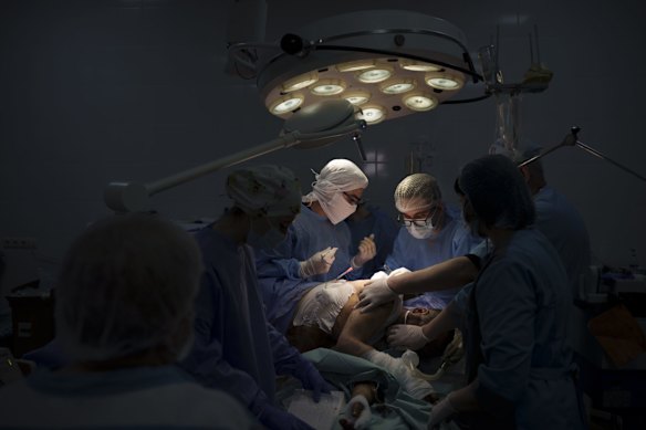 A Ukrainian soldier injured in combat against Russian forces undergoes surgery at a military hospital in Zaporizhzhia.