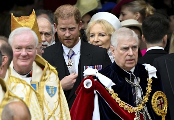 Prince Harry, Duke of Sussex (centre) and Prince Andrew (right) leave Westminster Abbey following the coronation.