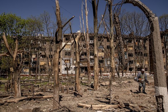 A man cleans up debris from a residential apartment block damaged by a Russian missile strike in Kramatorsk.