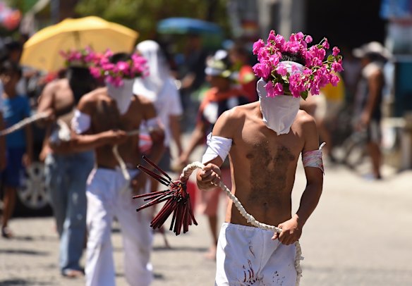 Atoning for their sins, men carry out the decades long tradition of self flagellation, whipping their backs with 25 bamboo sticks through the streets of Barangay San Pedro Cutud in Pampanga north of Manila.