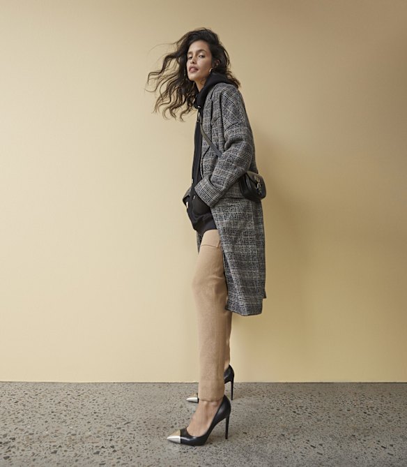 Zara coat, $169. Dion Lee hoodie, $490. Camilla and Marc “Charlton” track pants, $300. Louis Vuitton “Urban Twist” pumps, $1480. Christian Dior bag, $4900.