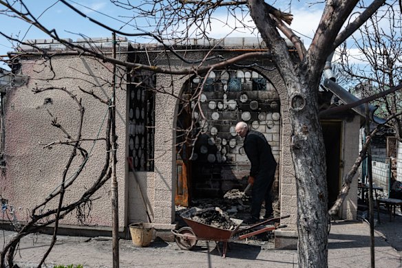 Volodymyr Futoryanyn, 73, clears the debris from his house in Zahaltsi.