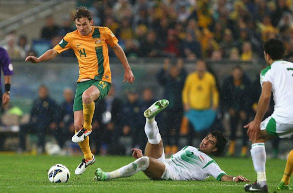 Brett Holman of the Socceroos is tackled by Ahmad Ibrahim of Iraq.