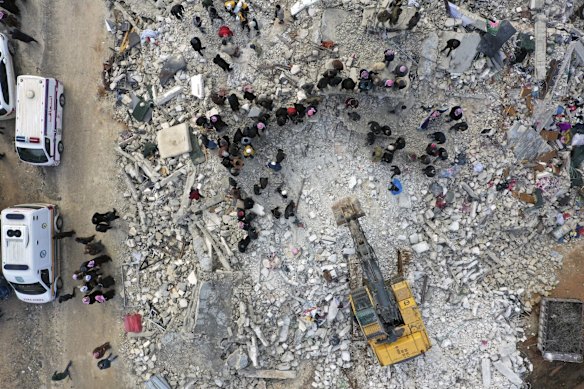 Civil defence workers and residents search the rubble of collapsed buildings in the town of Harem near the Turkish border, Idlib province, Syria.