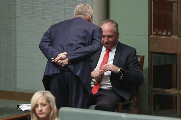Deputy Prime Minister Michael McCormack approaches the backbench for a discussion with Nationals MP Barnaby Joyce during question time on Tuesday.