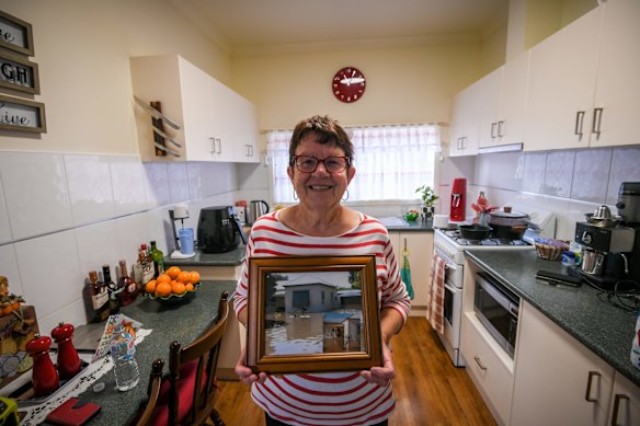 Glenys with a photo of their home in the 1974 floods.