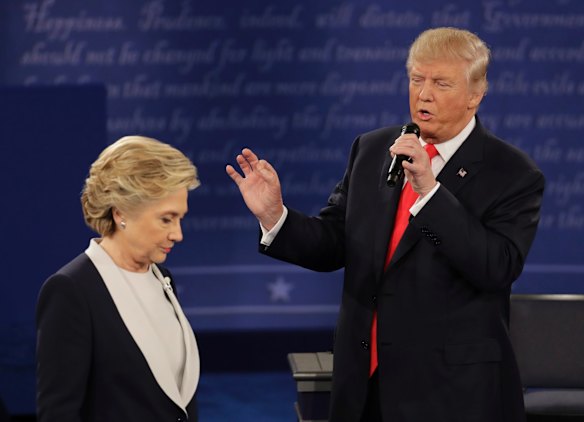 Democratic presidential nominee Hillary Clinton walks past Republican presidential nominee Donald Trump.