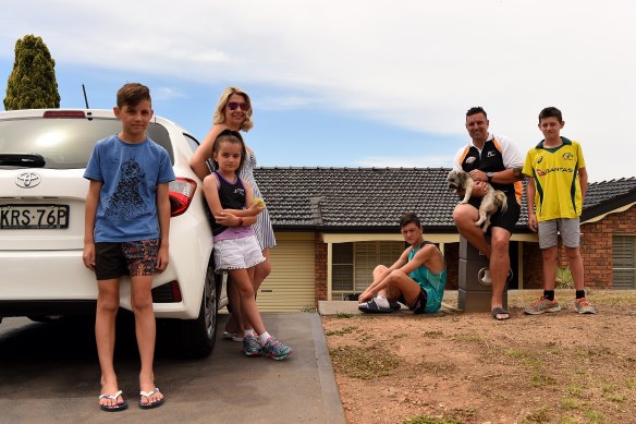 The Haywood family in front of their Erskine Park home. (From left to right) Ryan Haywood, 11, Keeley Haywood, 8, Kristy Haywood, 41, Lachlan Haywood, 15 and Cameron Haywood, 40, holding Tigah, and Joel Haywood, 13. 