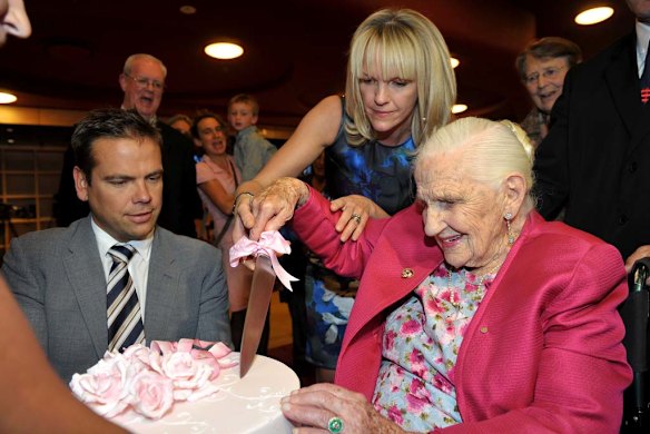 Dame Elisabeth gets ready to cut the cake at her 103rd birthday celebrations.