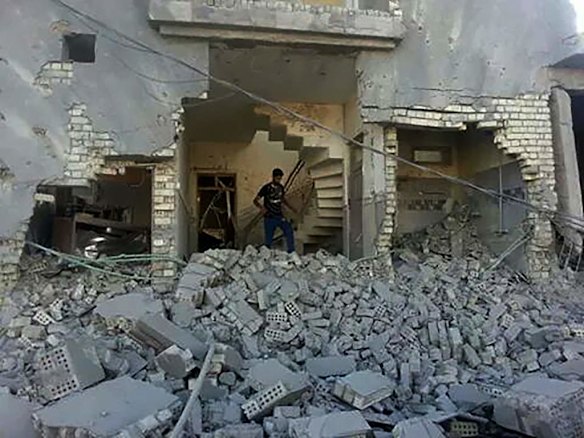A man walks amongst the rubble of destroyed buildings in the streets of Fallujah, a city under the control of the Islamic State, also known as ISIS. Fallujah, Iraq.