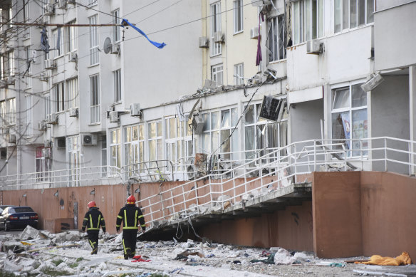 Firefighters walk past an apartment building damaged by Russian shelling in Odesa.