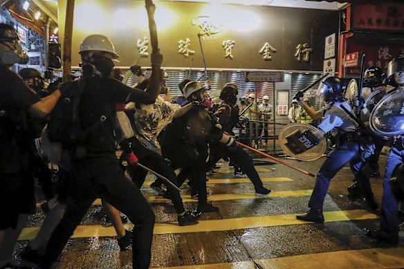 Policemen clash with demonstrators on a street during a protest in Hong Kong, Sunday, Aug. 25, 2019. 