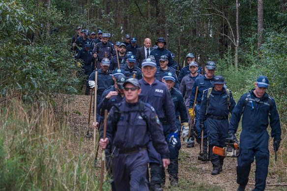 Police returning after the first day of a large-scale forensic search in bushlands, Kendall.