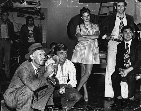 Paul Hogan in his "Smithy" guise critically watches an instant reply of a scene that has just been taped. Beside him from left to right are John Cornell, Delvene Delaney, Andrew Harwood and actor-magician Cecil Porkee. May 19, 1975.