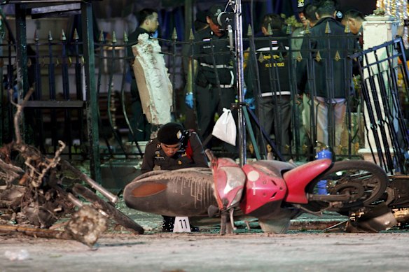 Experts investigate the remains of destroyed motorcycles at the Erawan shrine, the site of the blast in central Bangkok August 17, 2015. 