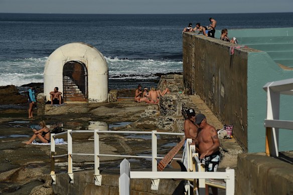 People dry off after a swim, near the ocean baths at Newcastle, as temperatures rise during lockdown.