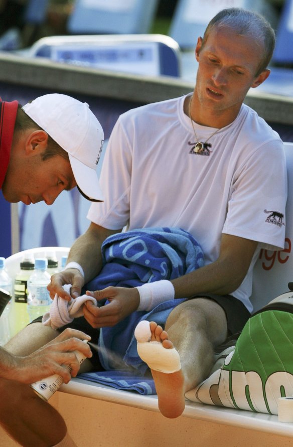 Nikolay Davydenko, right, receives treatment on his foot during his second round match with Martin Vassallo Arguello, of Argentina, at the Prokom Open in Sopot, Poland in 2007. 
