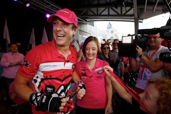 Samuel Johnson celebrates  crossing the finish line after his year-long Love Your Sister unicycle trek.