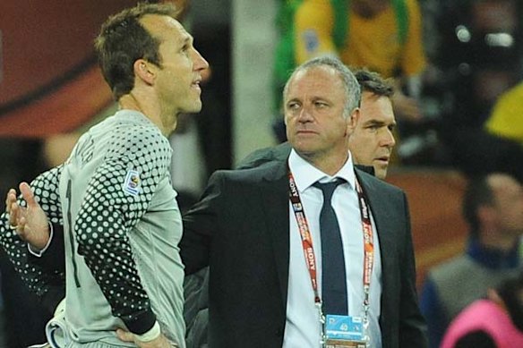 Mark Schwarzer is comforted by Graham Arnold.