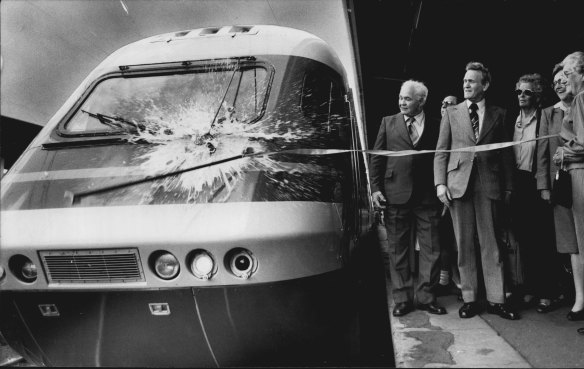 “Mrs. Ada Quinnell of Lithgow pulls a ribbon to crack a bottle of champagne over the XPT before its first passenger run yesterday.”