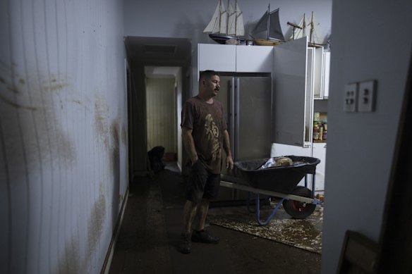 Matt Cutting stands among the ruins of his home after flooding reached the second storey.