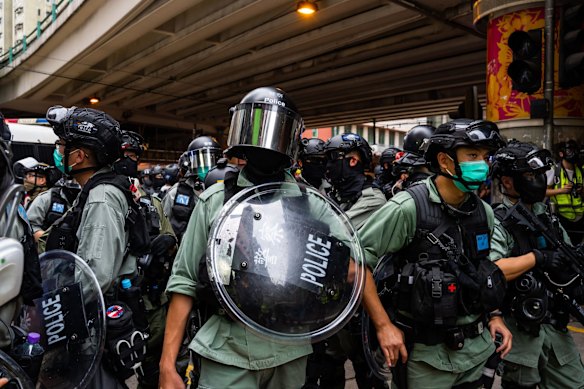 Riot police stand guard during an anti-government rally.