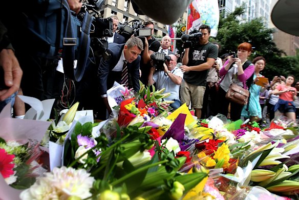  NSW Premier Mike Baird lays flowers at Martin Place after the siege where two hostages died in the early hours of Tuesday morning. 