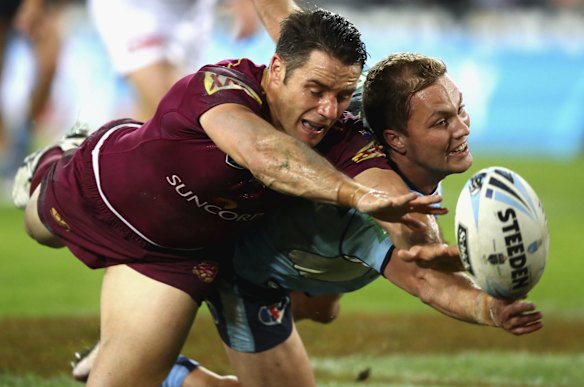 Cameron Smith of the Maroons and Matt Moylan of the Blues fight for the ball.
