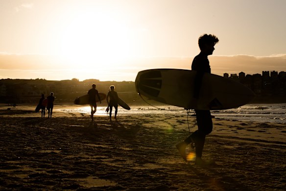Surfers race to the water at Bondi beach. 