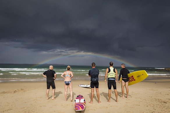 Locals take in a rainbow in front of a stormfront which rolled over Cronulla beach last Friday. 