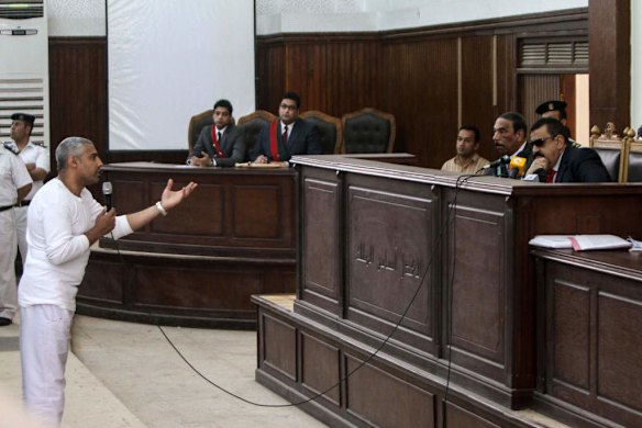 Qatar-owned broadcaster's English channel Cairo bureau chief Mohamed Fahmy (L) speaks to Egyptian judge Mohamed Nagy Shehata (R) after being allowed to leave the defendant cage during the trial of 20 individuals, including five Al-Jazeera journalists, for allegedly defaming the country and ties to the blacklisted Muslim Brotherhood on May 3, 2014.