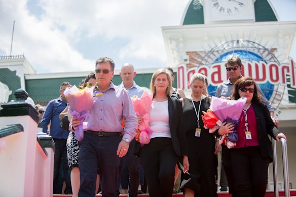 Dreamworld chief executive Craig Davidson and Ardent Leisure CEO Deborah Thomas leave flowers at the site on Friday after a private memorial service at Dreamworld.
