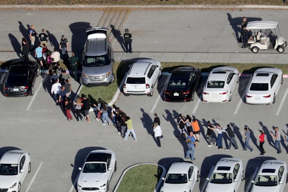 Students are evacuated by police from Marjorie Stoneman Douglas High School in Parkland, Fla., on Wednesday, Feb. 14, 2018, after a shooter opened fire on the campus. 