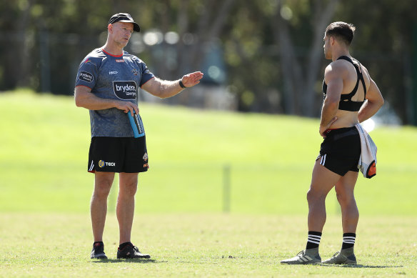 Michael Maguire talks to a Tigers player on the training paddock shortly before the NRL was suspended.