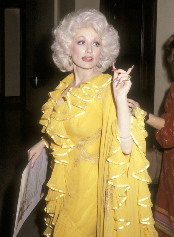 Dolly Parton in 1979, when Los Angeles mayor Tom Bradley proclaimed Dolly Parton Day in her honour. Here, she wears another favourite colour – yellow – in the form of a ruffled chiffon gown embroidered with butterflies.