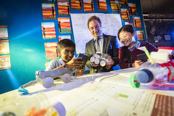 Years 4 students at St Christopher's Primary School, Therese and Naethan, work on their science projects with principal Shane Davoren. 