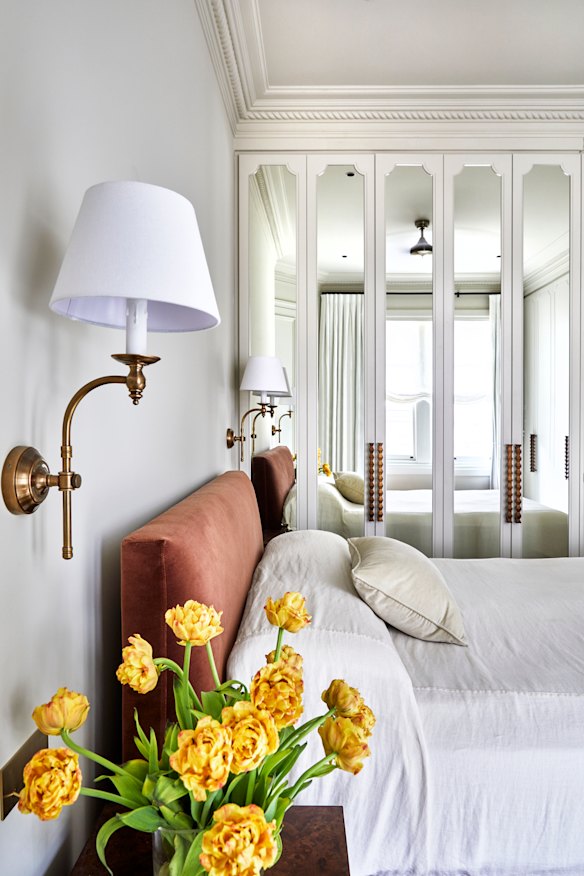 Custom-made mirrored cabinetry provides storage and reflects light. The “Soho” wall lights are from Florabelle Living, the “Burlington” bed from Coco Republic.