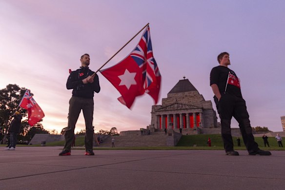 People holding the Australian Red Ensign pay their respects during the Anzac Day Dawn Service at the Shrine of Remembrance in Melbourne, Saturday, April 25, 2019. 