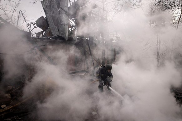 A firefighter works to extinguish a fire at a warehouse caused by recent Russian shelling in Kharkiv, Ukraine.