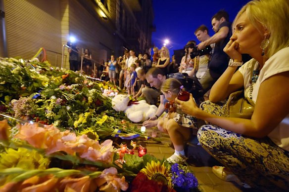 A woman looks on before lighting a candle in front of the Embassy of the Netherlands in Kiev on July 17, 2014, to commemorate passengers of Malaysian Airlines flight MH17 carrying 295 people from Amsterdam to Kuala Lumpur which crashed in eastern Ukraine. Ukrainian President Petro Poroshenko said on July 17 that the Malaysia Airlines jet that crashed over rebel-held eastern Ukraine may have been shot down." Ukraine's government and pro-Russian insurgents traded blame for the disaster, with comments attributed to a rebel commander suggesting his men may have downed Malaysia Airlines flight MH17 by mistake, believing it was a Ukrainian army transport plane.