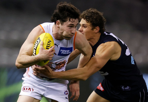 Lachie Ash is tackled by Charlie Curnow during Saturday’s clash. 