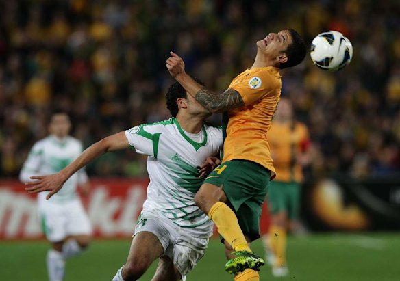 Tim Cahill heads the ball.