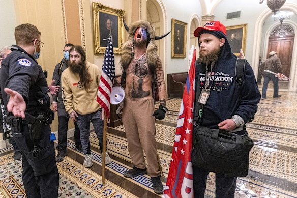 Supporters of President Donald Trump, including Jacob Chansley, centre with fur and horned hat, are confronted by Capitol Police officers outside the Senate Chamber inside the Capitol in Washington on January 6, 2021. Congress held a joint session to ratify President-elect Joe Biden's 306-232 Electoral College win over President Donald Trump. Pro-Trump protesters entered the US Capitol building after mass demonstrations.