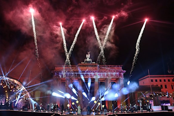 Musicians watch as fireworks explode over Berlin's landmark Brandenburg Gate during the New Year Celebrations in Berlin, Germany.