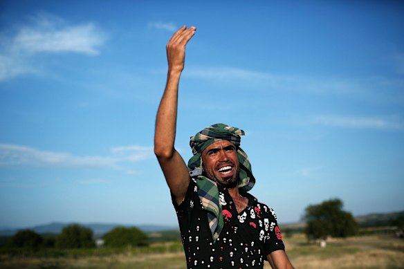 An Iraqi migrant calls to his family to join him on the next bus to the northern border shortly after they crossed the Macedonian border from Greece.