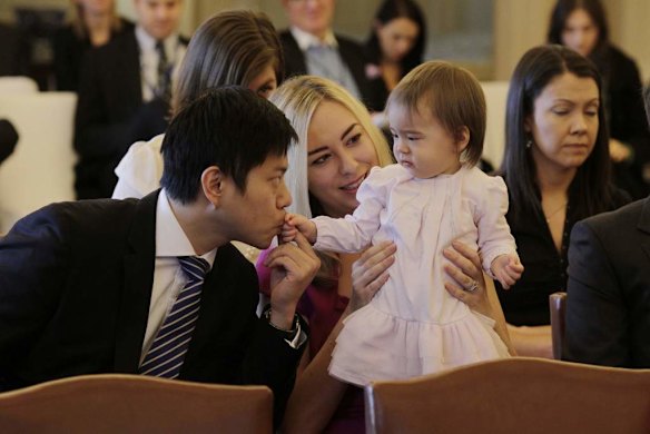 Albert Tse kisses his daughter Josephine as he and his wife Jessica Rudd wait for Kevin Rudd to be sworn in as Prime Minister at Government House in Canberra on Thursday 27 June 2013.