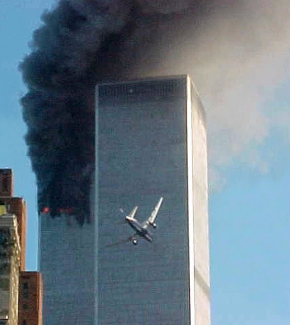 In this Sept. 11, 2001 photo, United Airlines Flight 175 approaches the south tower of the World Trade Center in New York shortly before collision as smoke billows from the north tower.