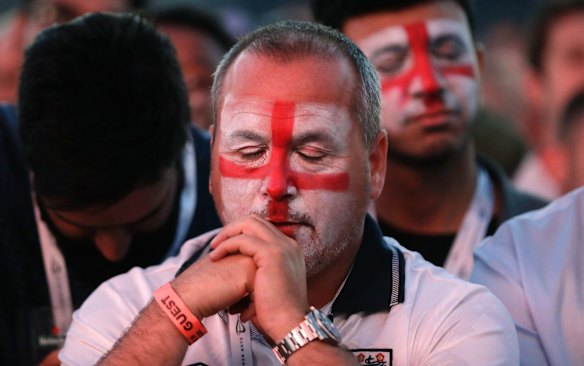 An England soccer fan reacts after Croatia scored their side's second goal as he watches a live broadcast on a big screen of the semifinal match between Croatia and England at the 2018 soccer World Cup, in Hyde Park, London.