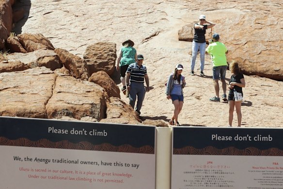 Visitors climbing up Uluru on the final day the climb is allowed.
