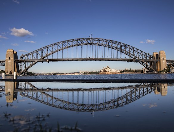 The Sydney Harbour Bridge as seen from McMahon's Point, and its reflection in a puddle.
